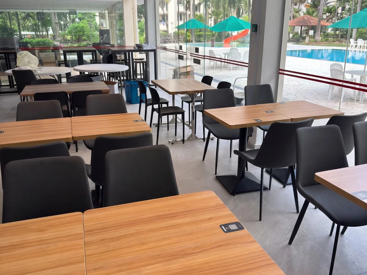 The same unit in service as a cafe, with timber-top tables and cushioned dining chairs supplied and assembled by Casa Furnishing